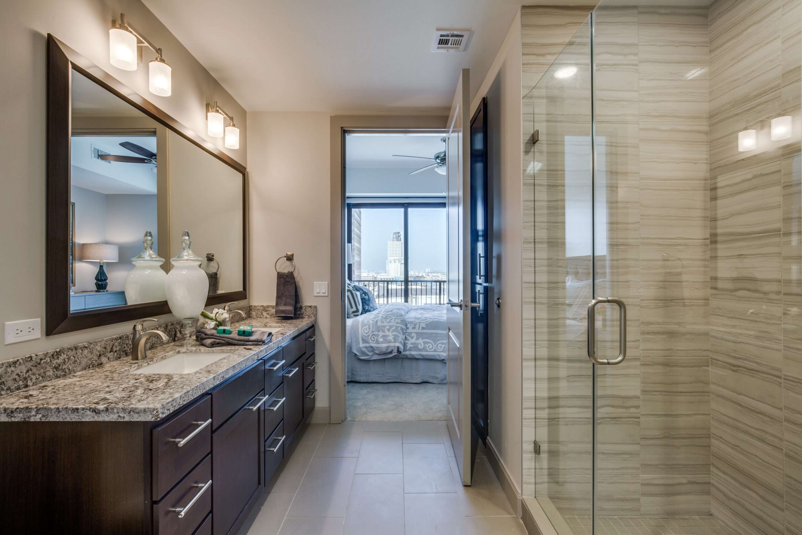 Bathroom at The McCarthy with a vanity, framed mirror and glass shower