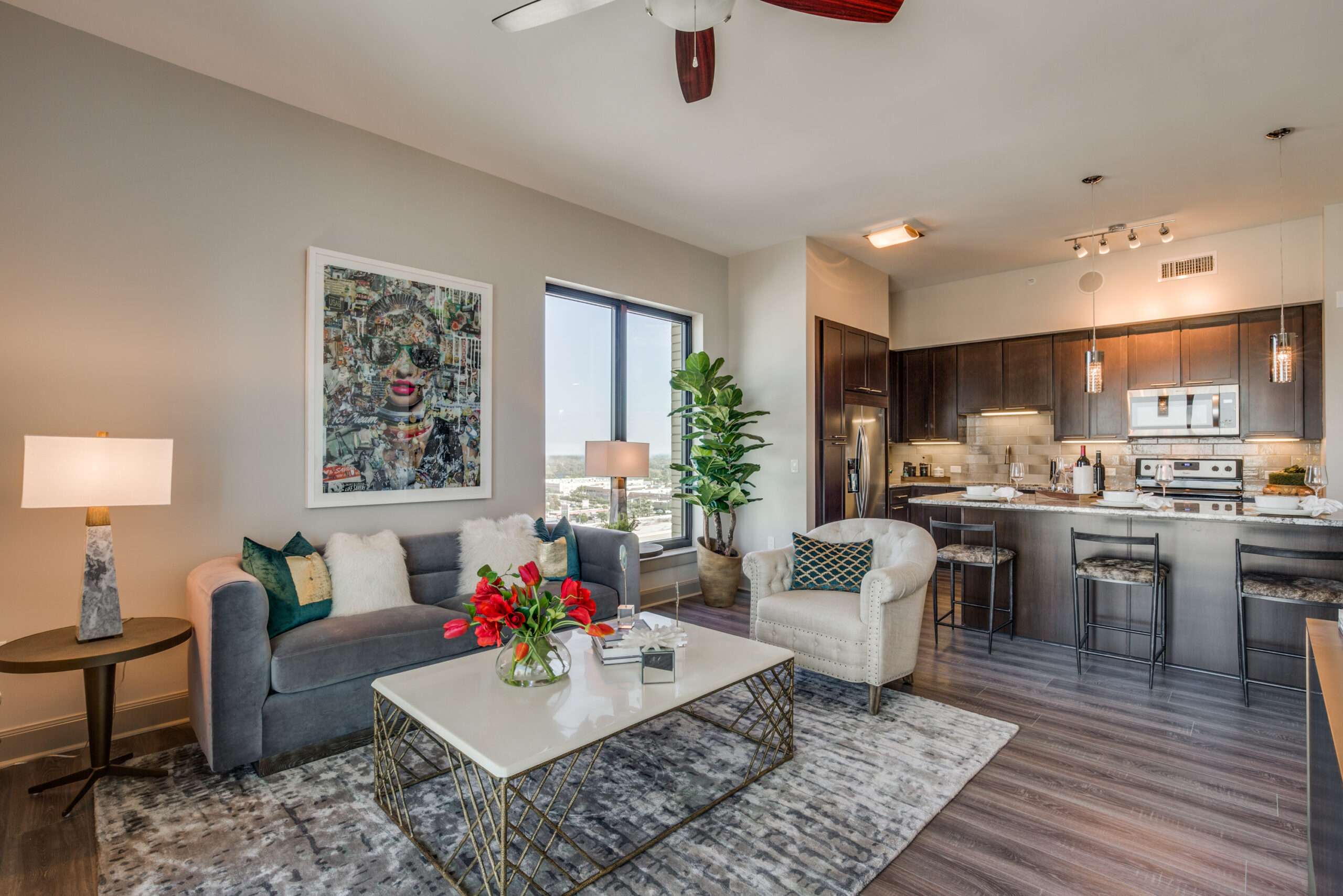 Combined living room and kitchen at The McCarthy with a grey sofa and dining area