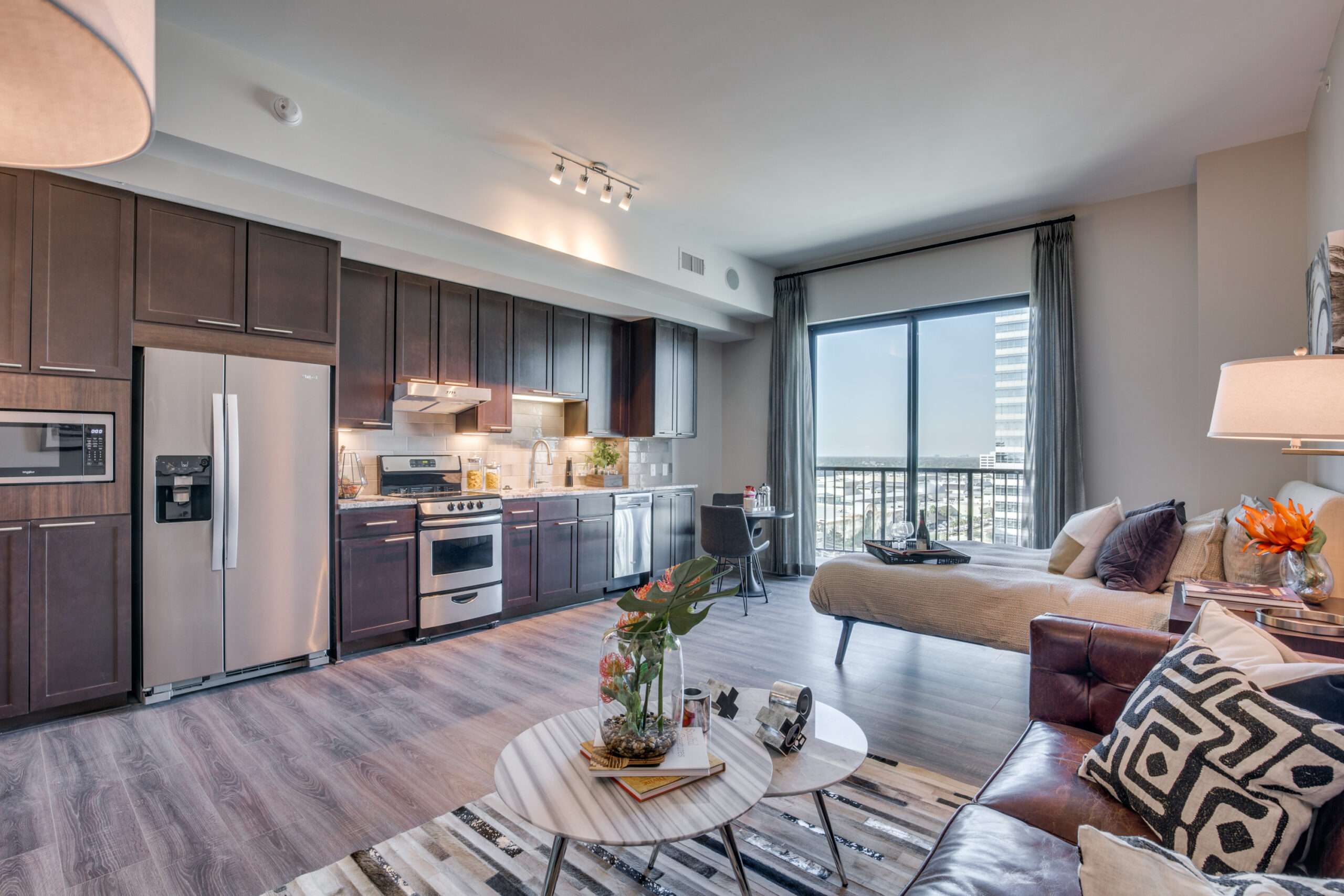 Living room and kitchen at The McCarthy with a sofa and doors to the balcony