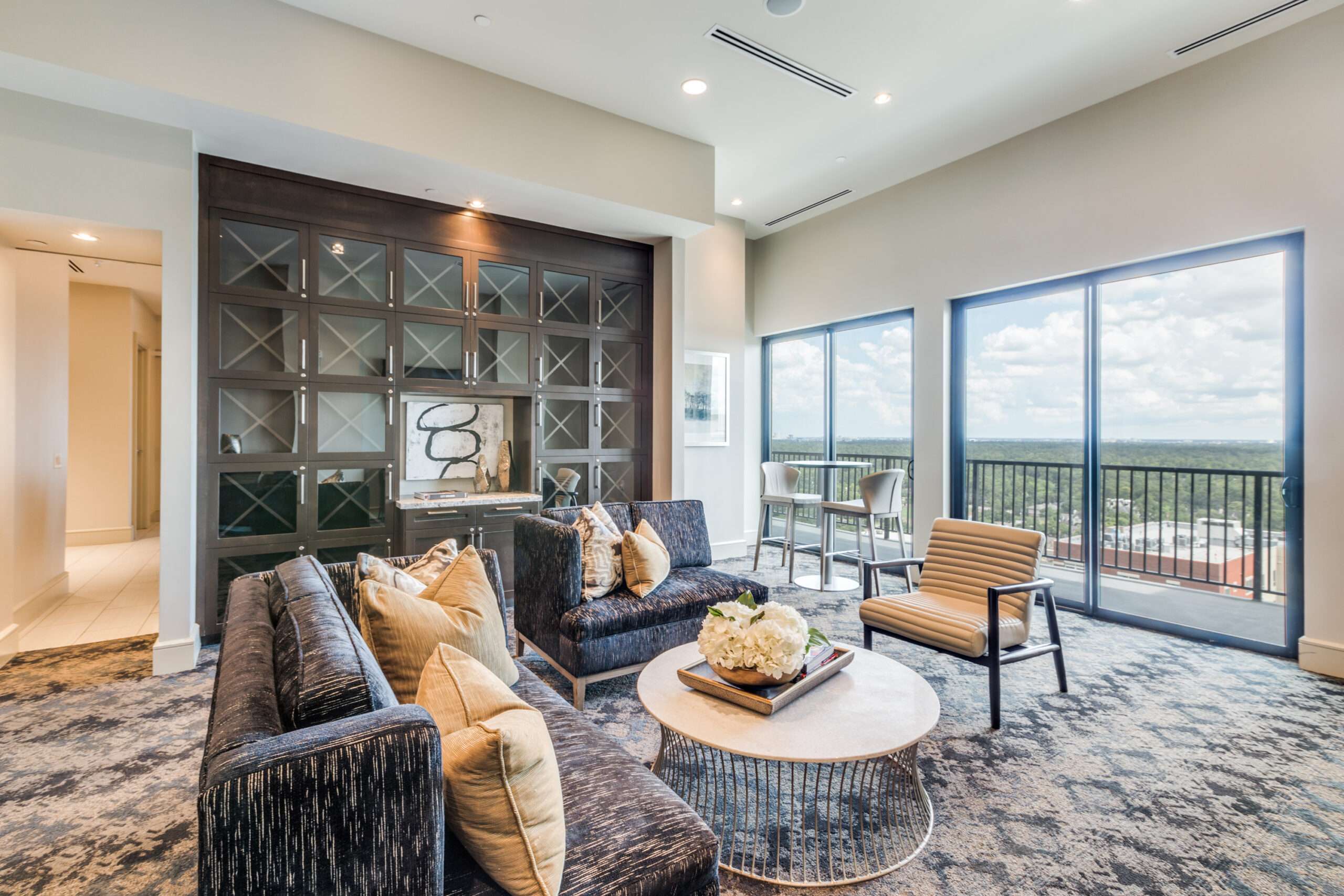 Sky lounge at The McCarthy with sofas and armchairs beside sliding doors to the balcony