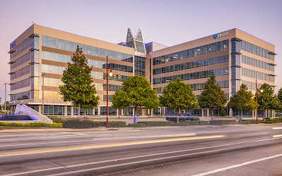 Multi-story office building at Greenside with a glass facade and young trees along the street