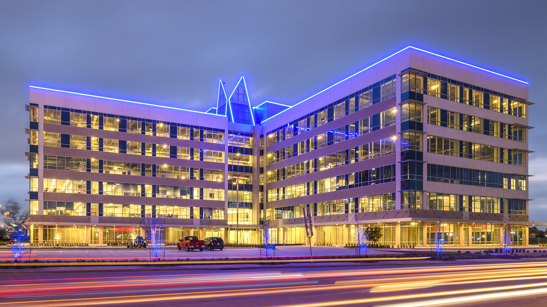 10100 Katy Freeway illuminated at night with coloured accent lighting and traffic light trails