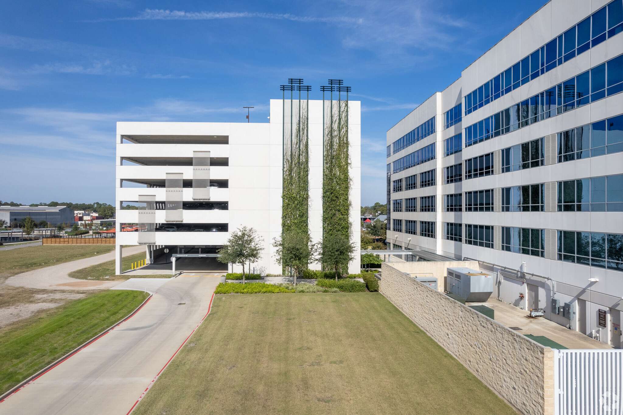 Landscaped drive leading to the office building and parking garage at 10100 Katy Freeway