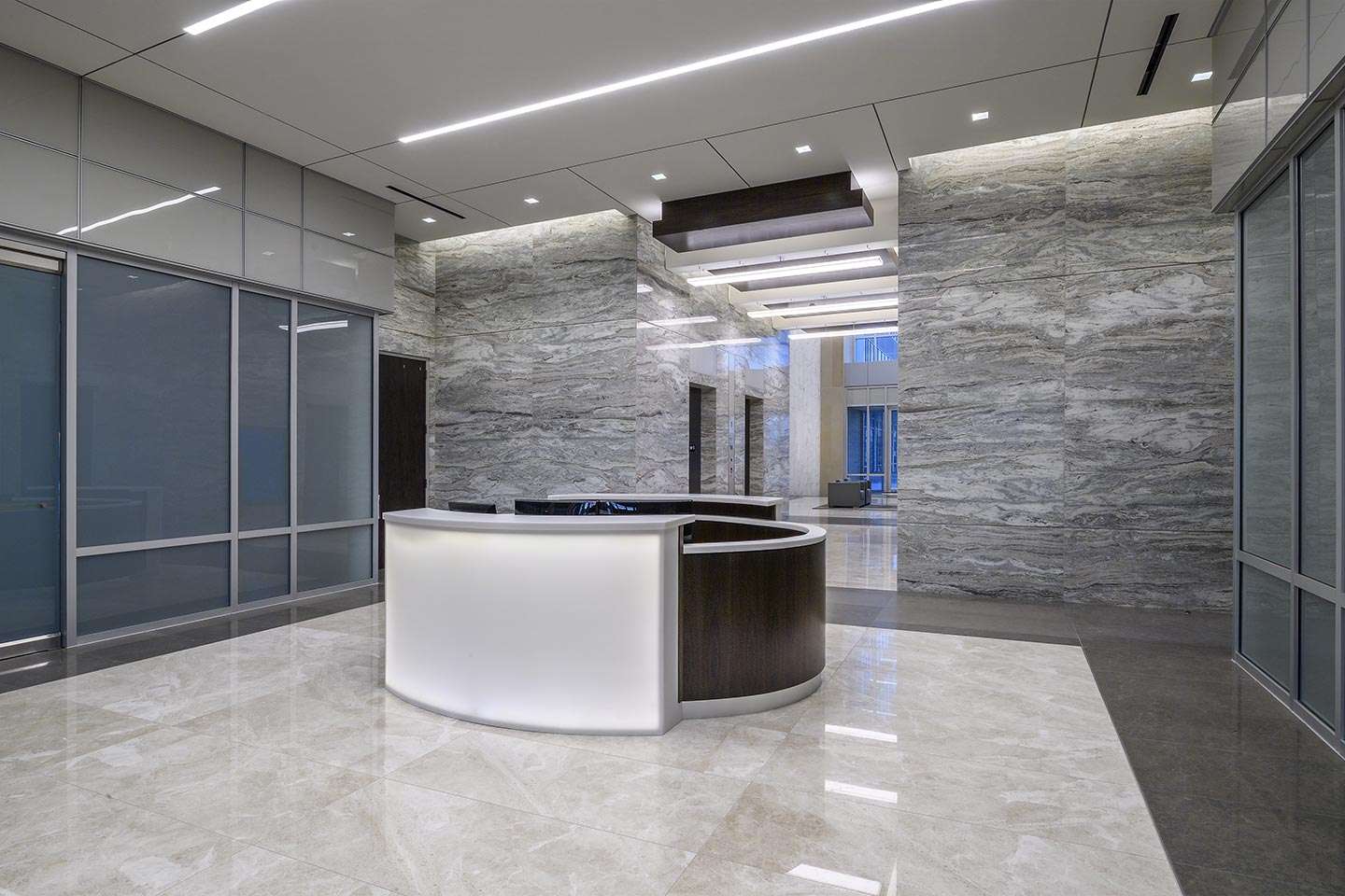 Reception desk in the marble lobby of 10100 Katy Freeway, lit from below