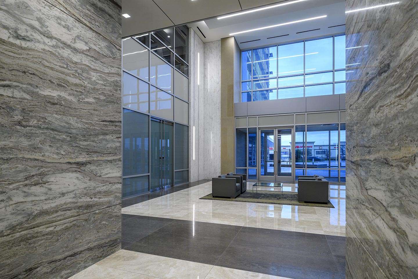 Marble-clad lobby entrance at 10100 Katy Freeway with glass doors to the street