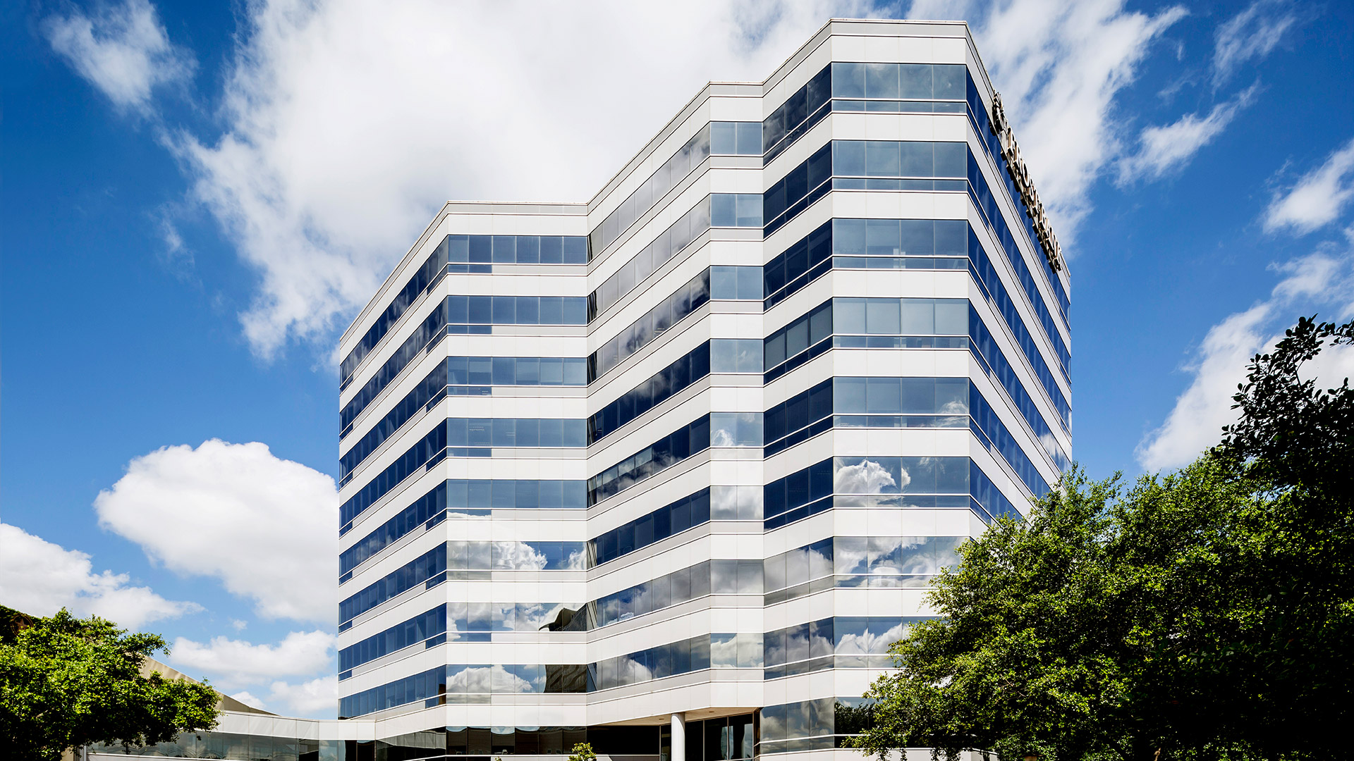 Exterior of Memorial City Place, a white and glass mid-rise office building