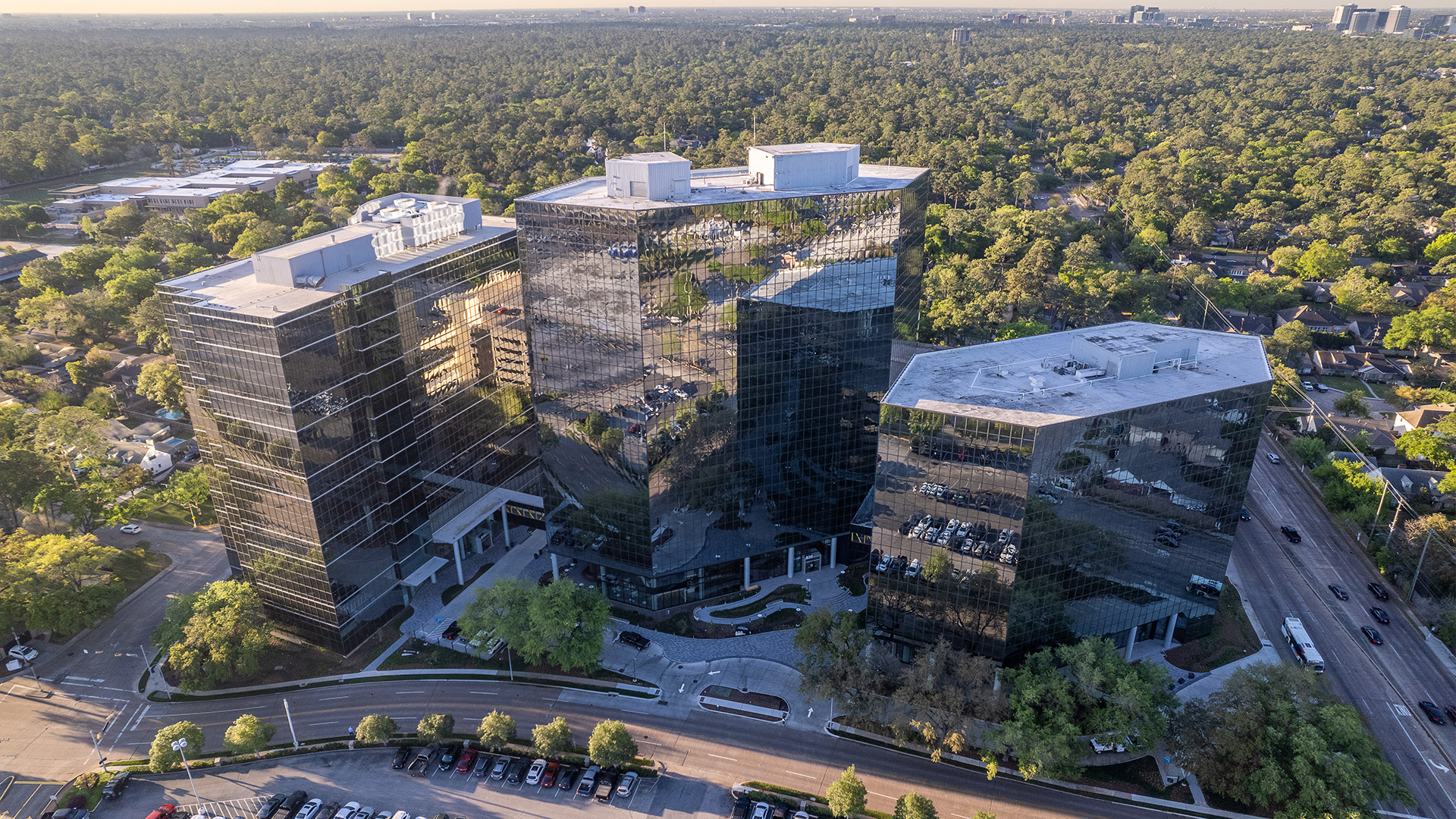 Aerial view of the Two Memorial City Plaza office towers among mature trees