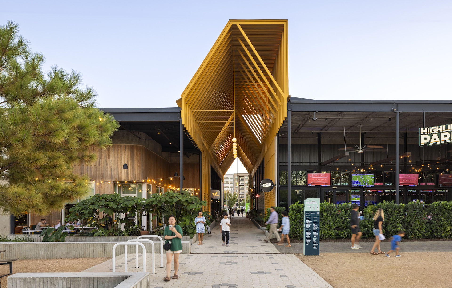 The promenade at M-K-T Heights beneath its angular yellow canopy, with people walking