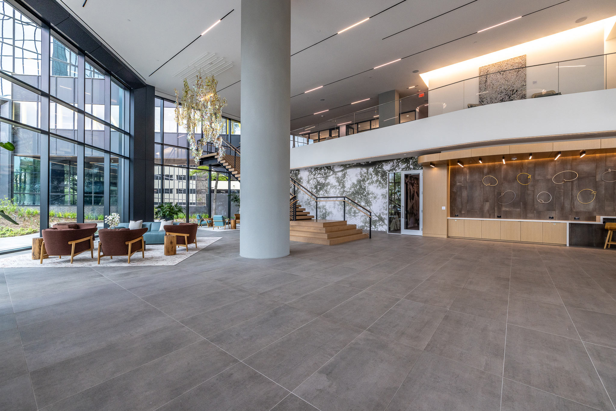 Double-height lobby at 800 Gessner Road with columns, seating and a mezzanine above