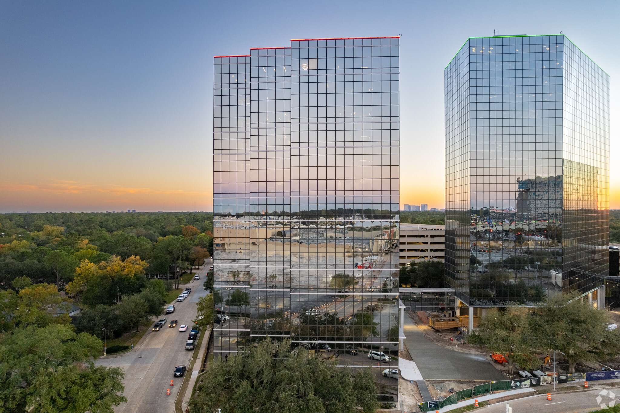 Aerial view of the twin mirrored towers at 840 Gessner Road above the tree line
