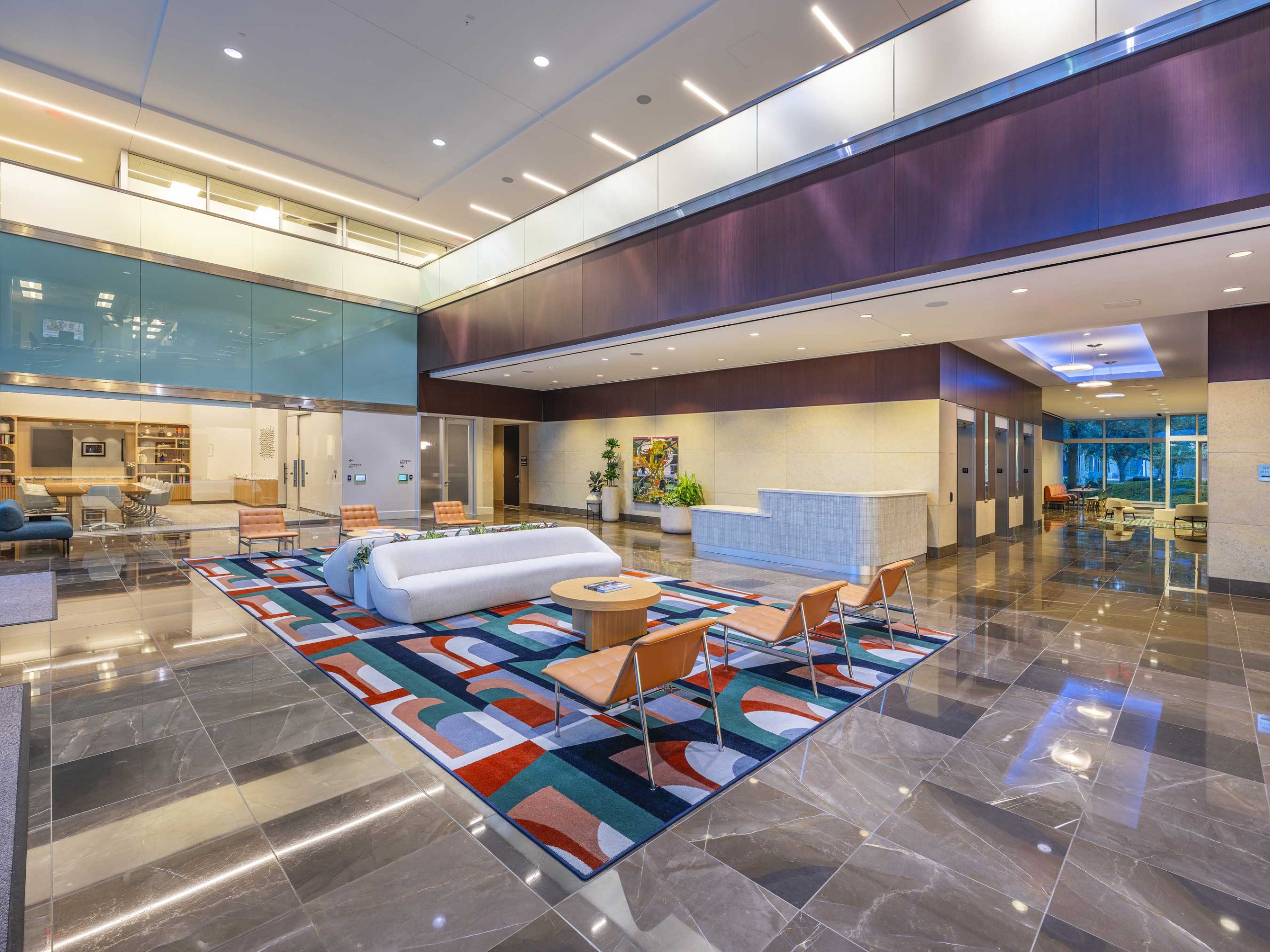 Lobby at 920 Memorial City Way with a colourful geometric floor pattern and seating beneath a curved soffit