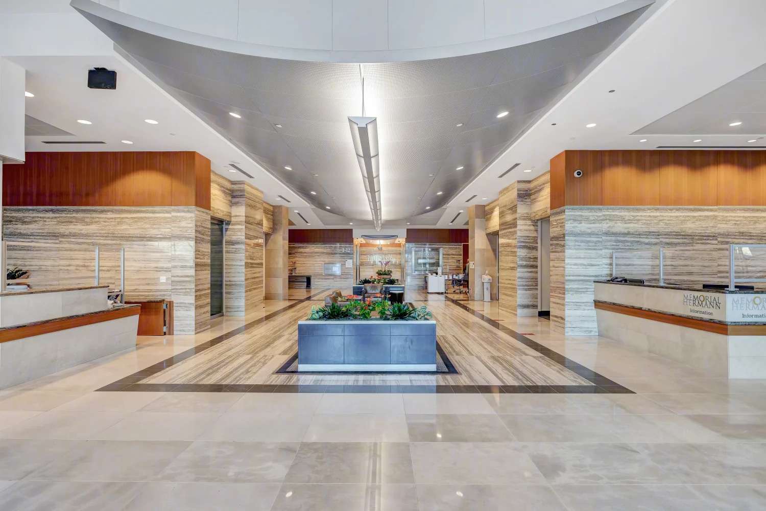 Lobby of 929 Gessner Road with a domed ceiling, stone walls and a central water feature