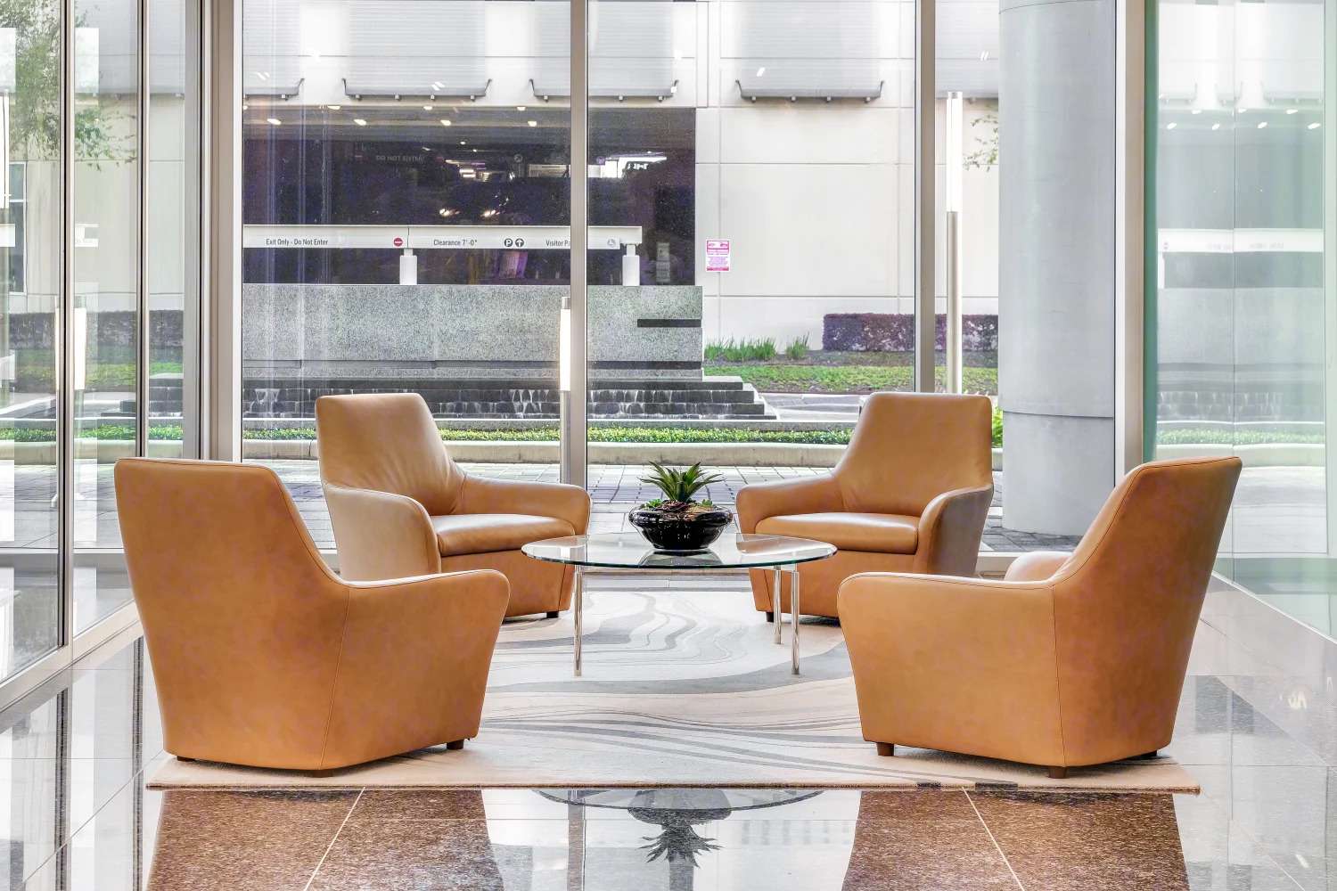 Lobby seating at Air Liquide Center South with tan armchairs around a round table on a marble floor