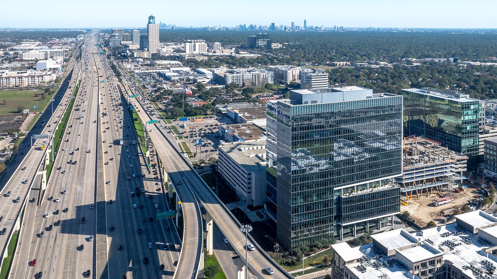 Aerial view along the freeway toward downtown Houston, with 990 Town & Country among the office buildings