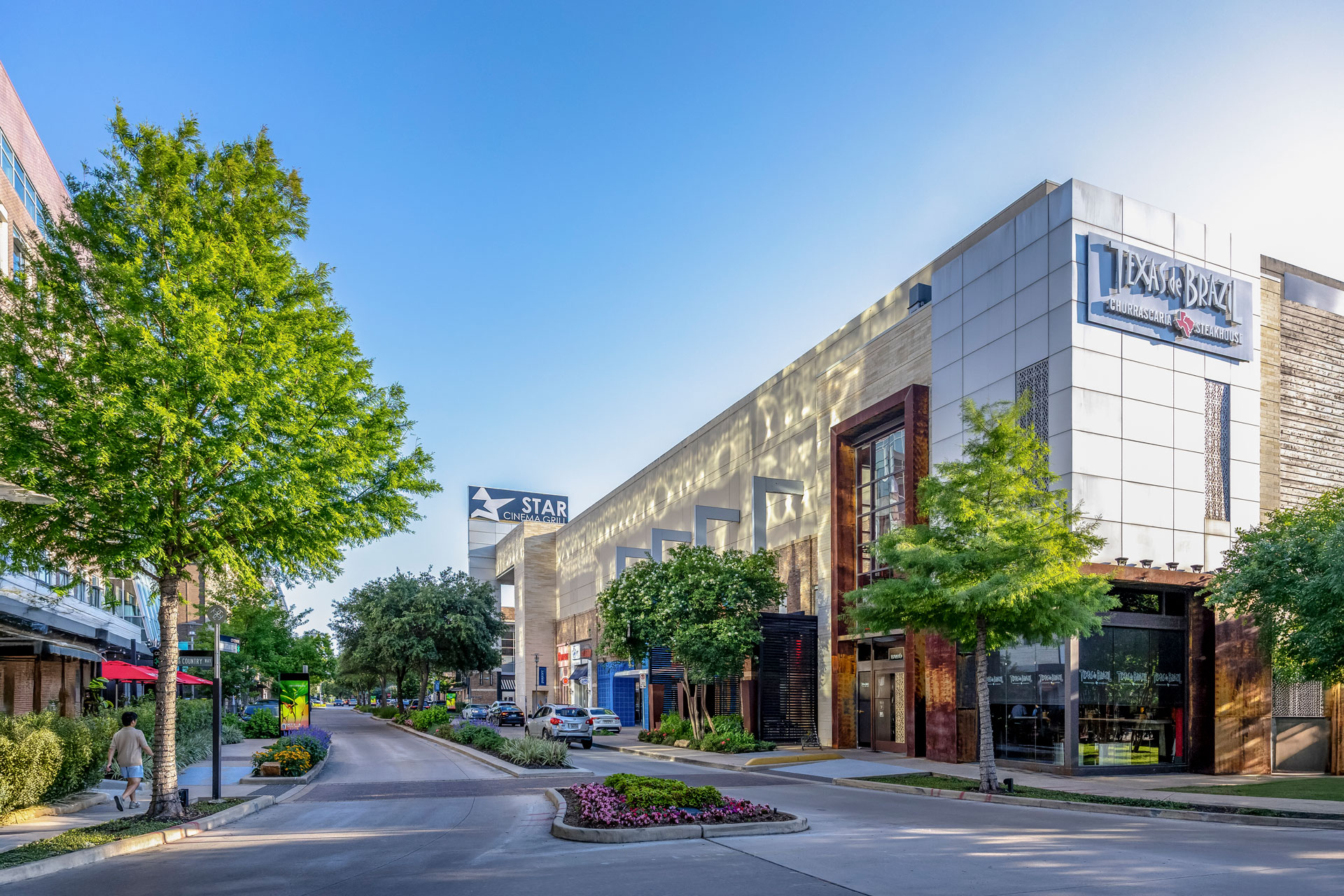 Street view of the retail buildings at CityCentre, lined with trees