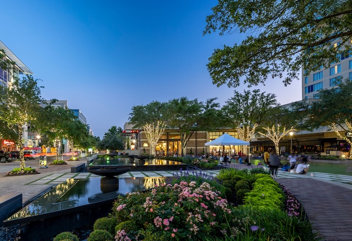 Landscaped canal at CityCentre at dusk, with lit buildings reflected in the water