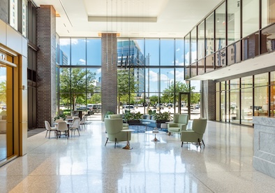 Conference Space Photos -18 Double-height conference lobby with green armchairs and full-height glass walls