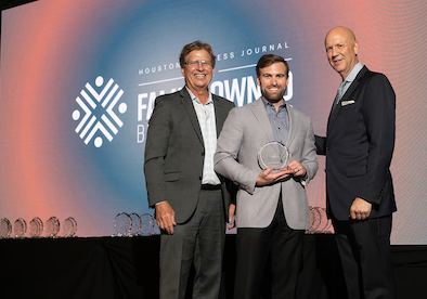 Family Owned Business Awards 2024 Three MetroNational representatives accepting an award on stage at the Houston Business Journal Family-Owned Business Awards