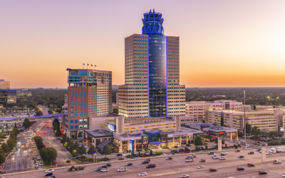 Gateway_Connect_CTA Aerial view of the Memorial City district at sunset, with its blue-lit tower at the center