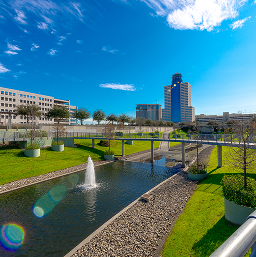 Greenside-Move-Recharge Landscaped waterway with fountains at Greenside, with office towers behind