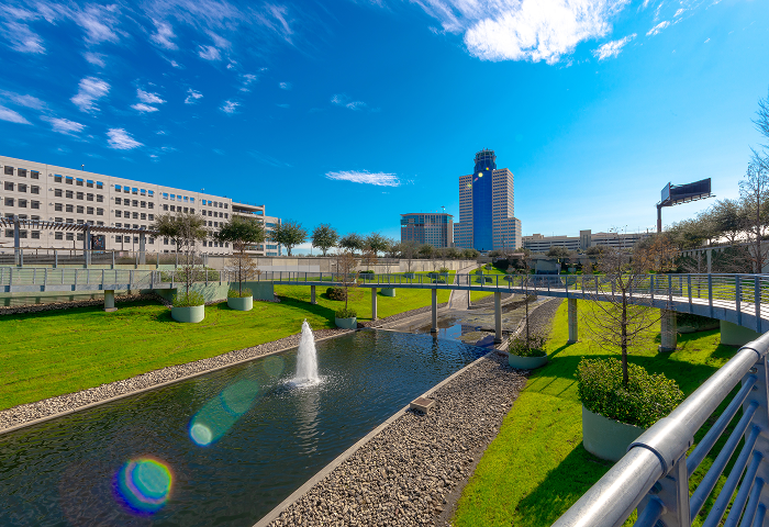 Landscaped waterway with fountains at Greenside, with office towers behind