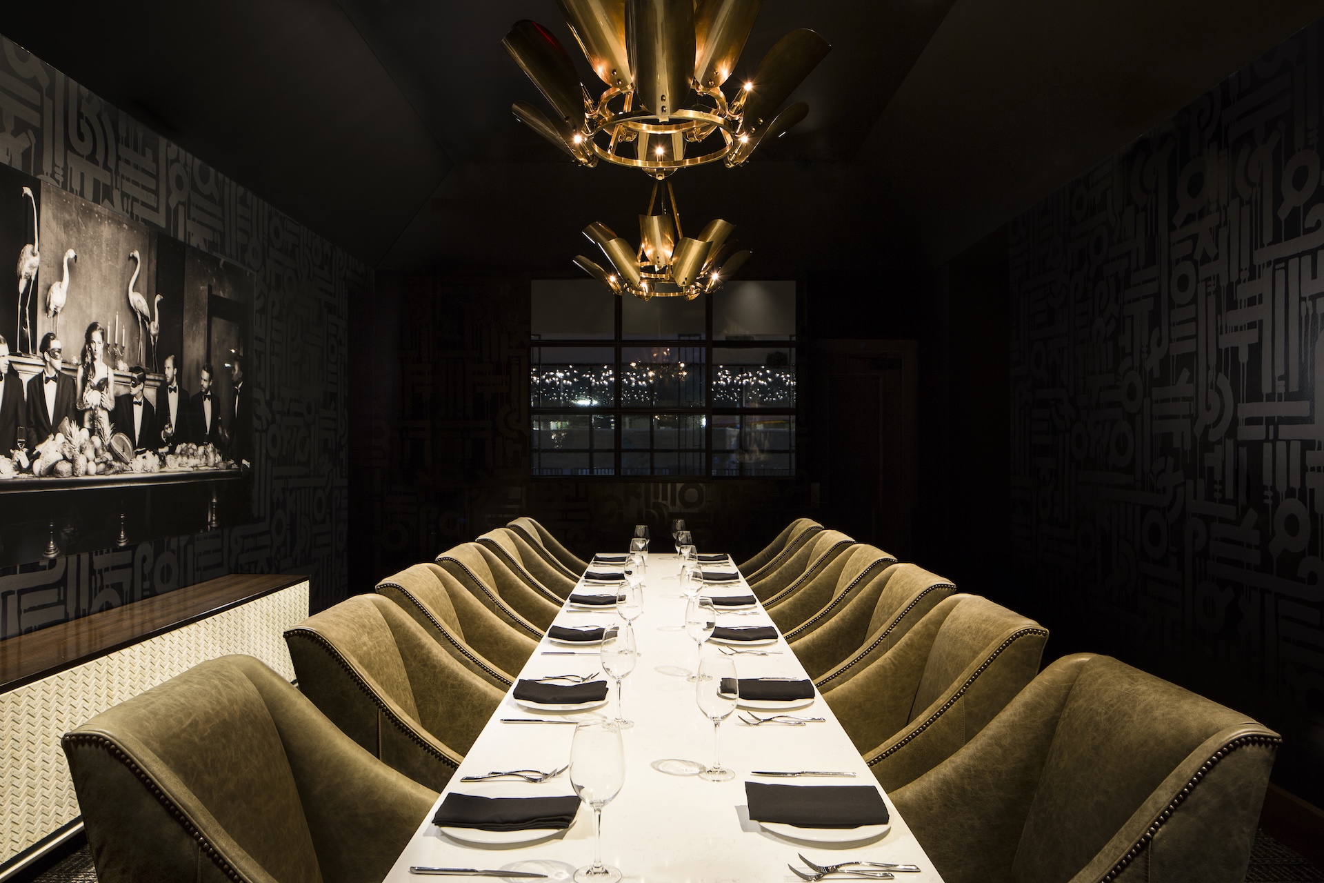 Private dining room at Tiger’s Wife in Hotel ZaZa Memorial, with gold banquette seating beneath a starburst chandelier