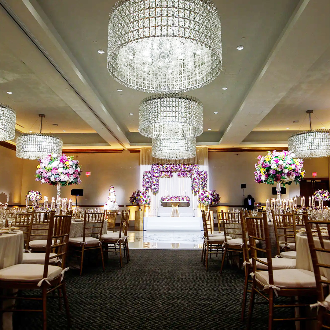 Ballroom at Hotel ZaZa Memorial set with round banquet tables, floral centrepieces and chandeliers