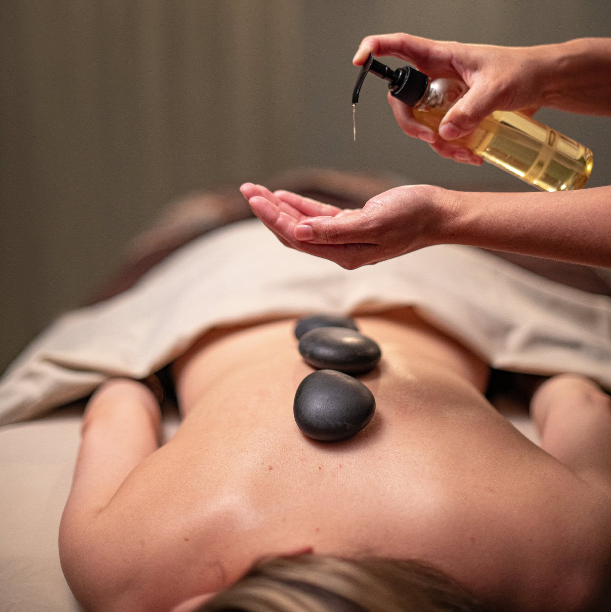 Hot stone massage in progress at the Hotel ZaZa Memorial spa, with oil being applied