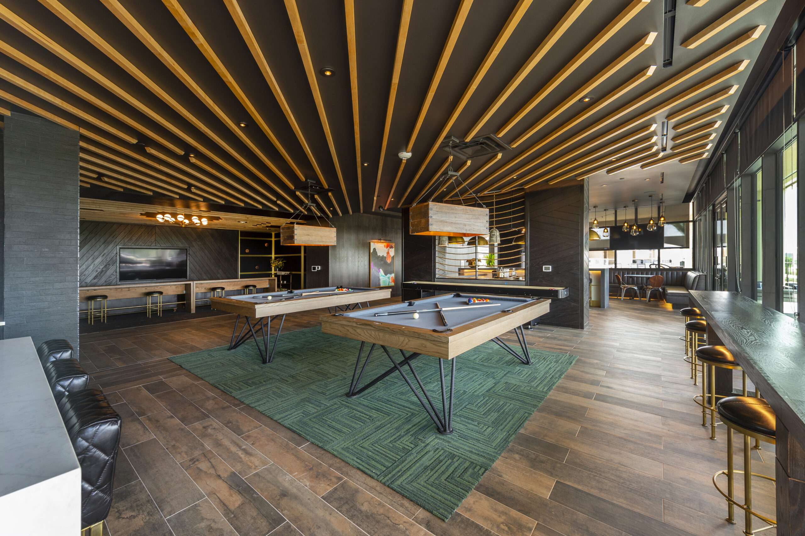 Game lounge at The McAdams with a pool table beneath a fanned wood slat ceiling