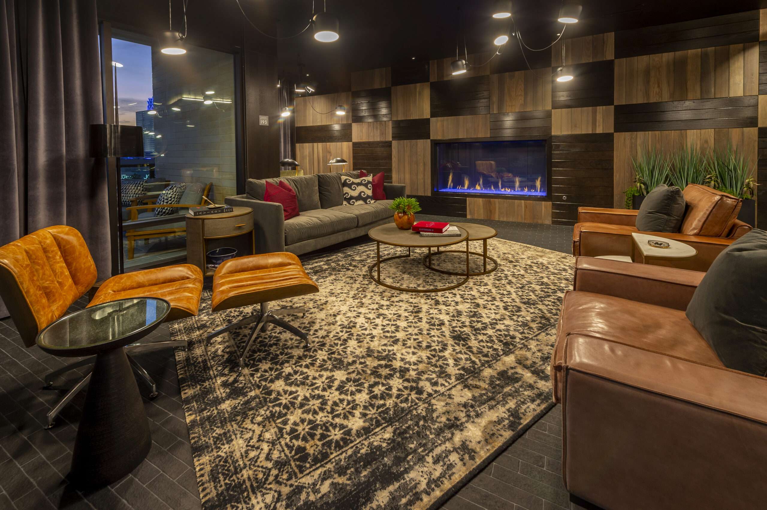 Resident lounge at The McAdams with a fireplace, leather armchairs and a patterned rug