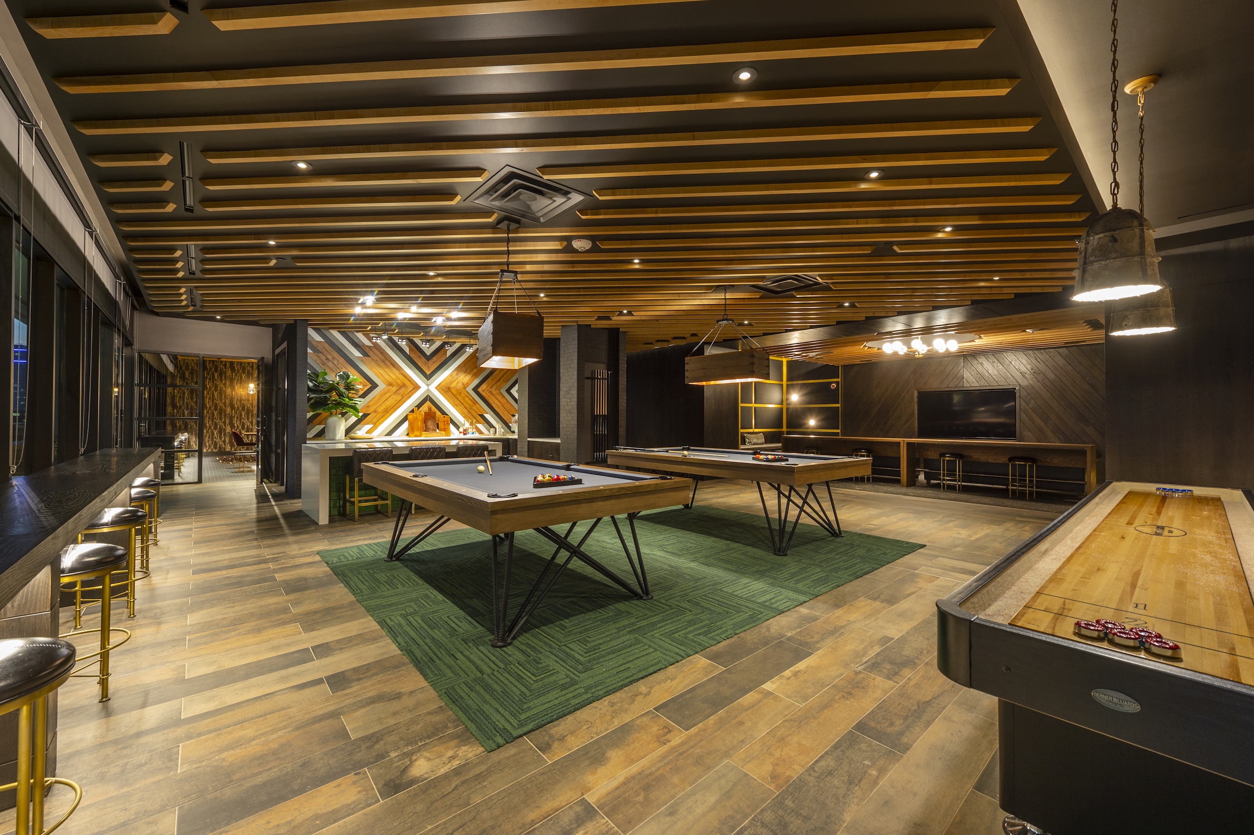 Game room at The McAdams with a shuffleboard table, foosball and a wood slat ceiling