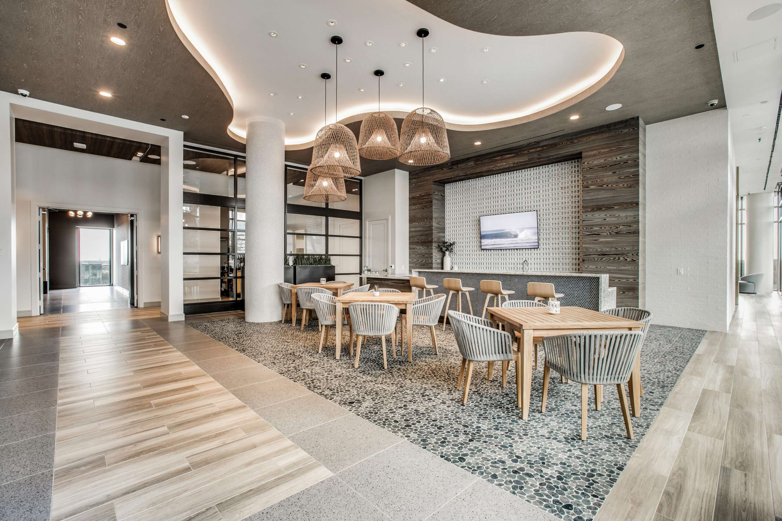 Lounge and dining area at The McKinley beneath a curved sculptural chandelier