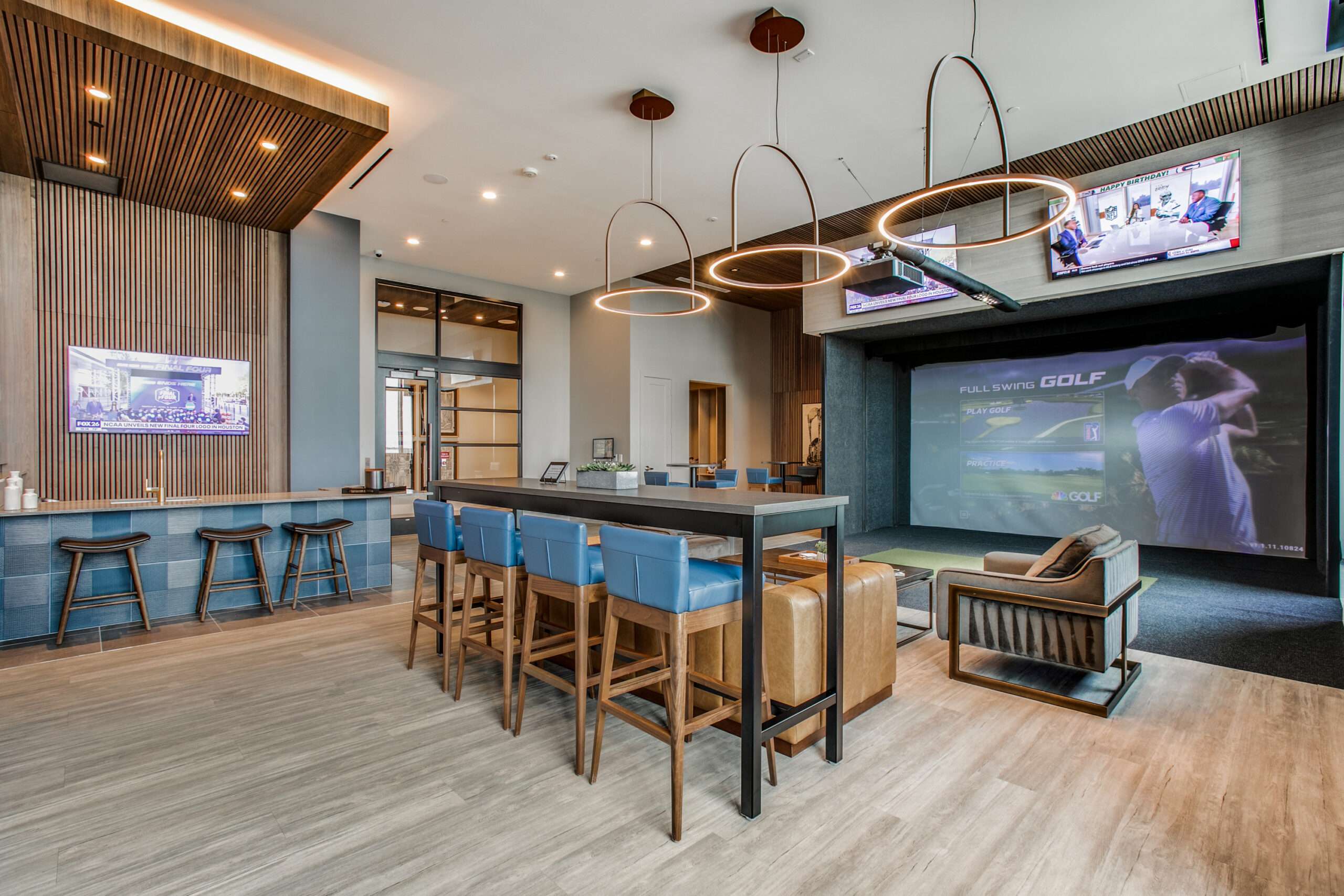 Entertainment lounge at The McKinley with a bar, stools and a large screen