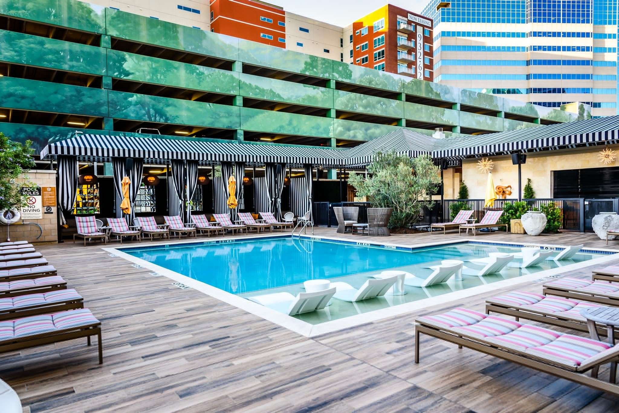 Pool deck at Hotel ZaZa Memorial with striped cabanas and lounge chairs