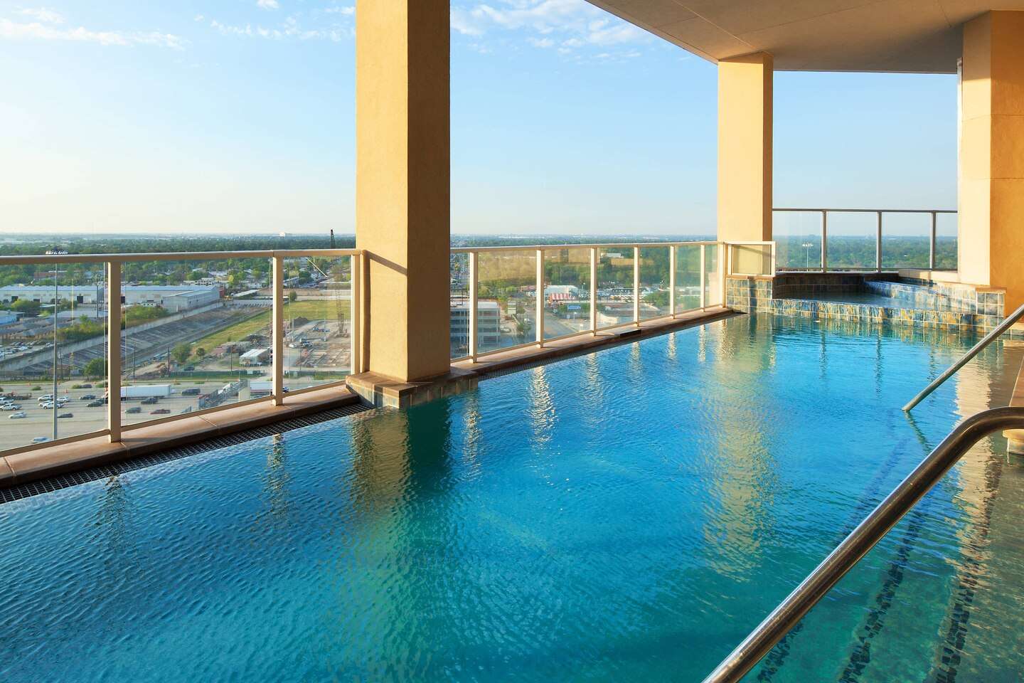 Elevated outdoor pool at The Westin Memorial, framed by columns and overlooking the highway below