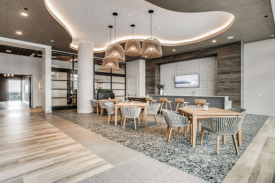 Leasing lounge with a curved ceiling, pendant lighting and a communal dining table