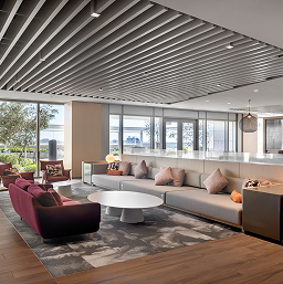 Office lounge at CityCentre with a sectional sofa, round coffee table and slatted ceiling