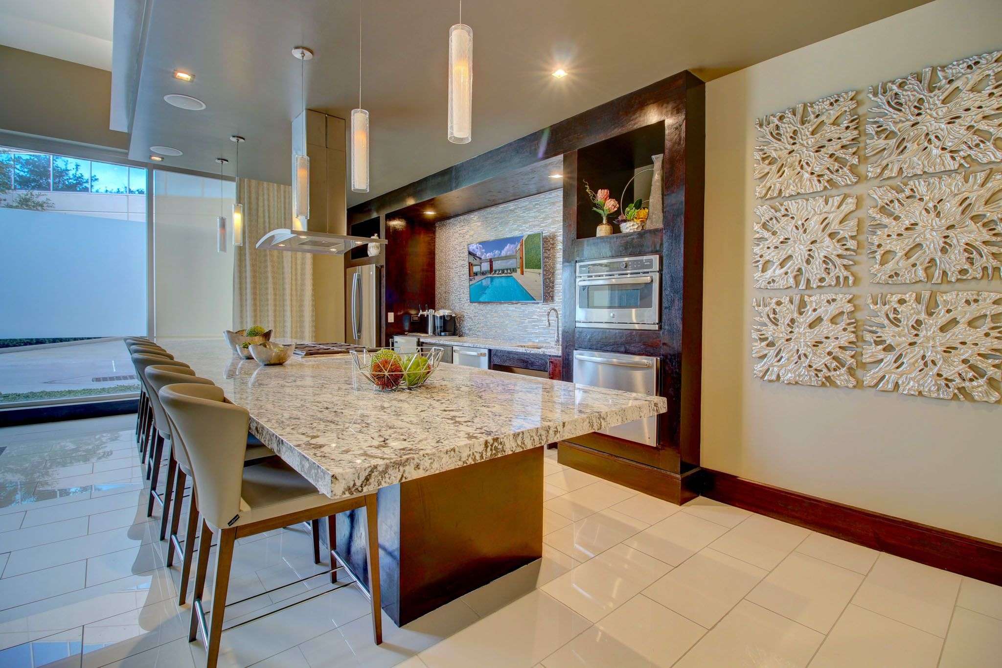 Kitchen at The Fountains with a granite island, bar stools, pendant lights and stainless appliances