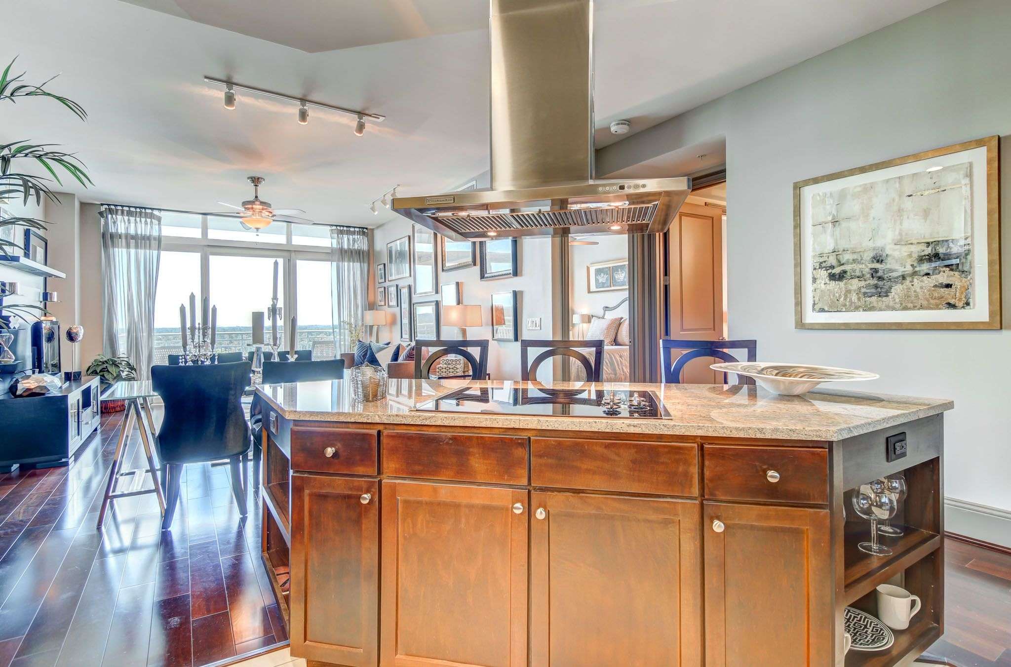 Open kitchen at The Fountains with a large wood island, range hood and hardwood floors