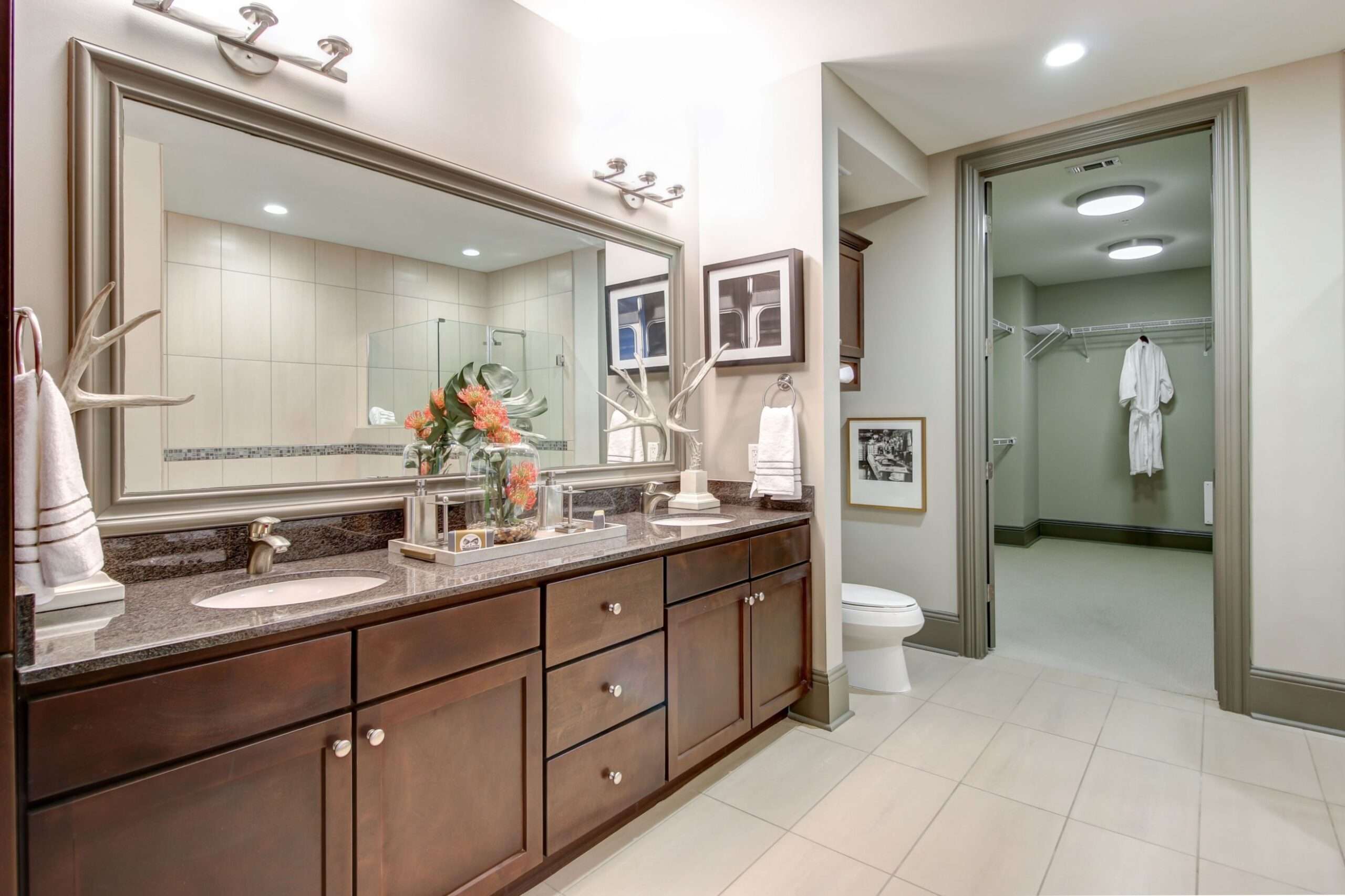 Bathroom at The Fountains with a double vanity, large mirror and tile floor