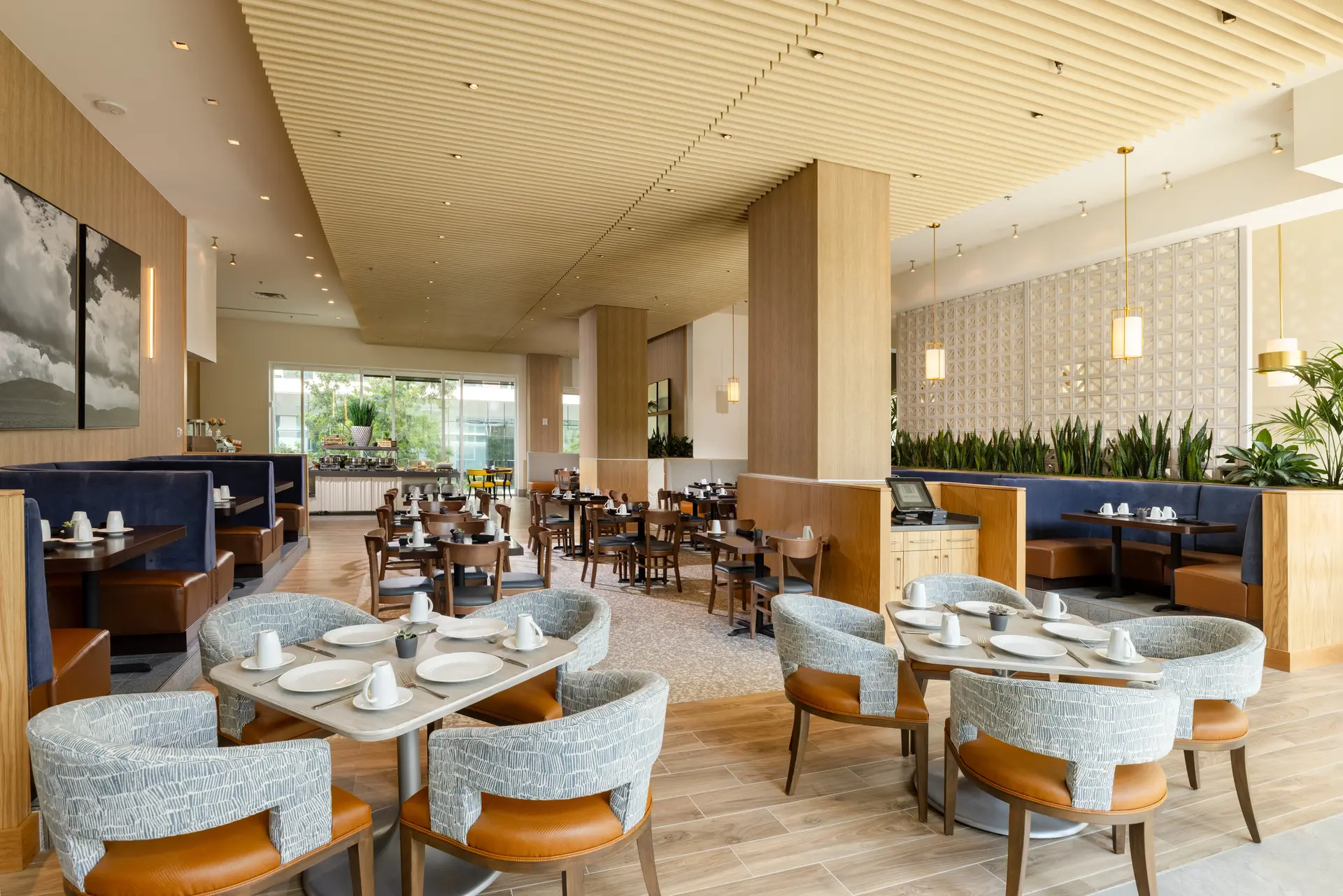 The-Moran-06 Dining room at The Moran Hotel with round tables, teal upholstered chairs and a slatted wood ceiling
