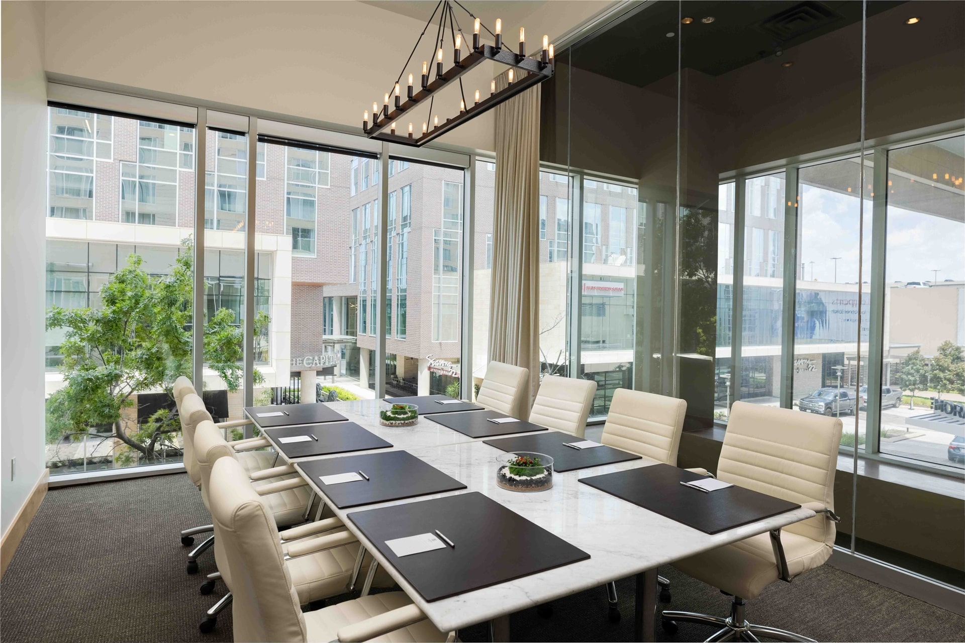 The-Moran-19 Glass-walled meeting room at The Moran Hotel with a long conference table and leather chairs