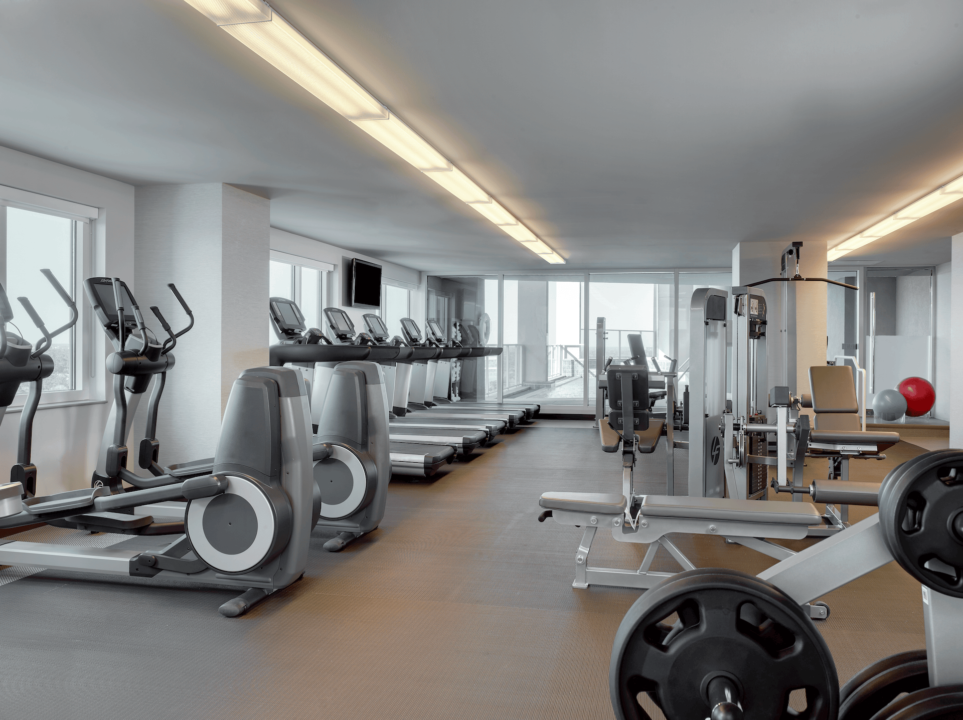 Fitness center at The Westin Memorial with treadmills, weight machines and floor-to-ceiling windows