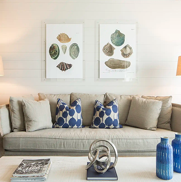 Sofa with blue patterned cushions beneath framed artwork at the Hotel ZaZa Memorial beach house suite