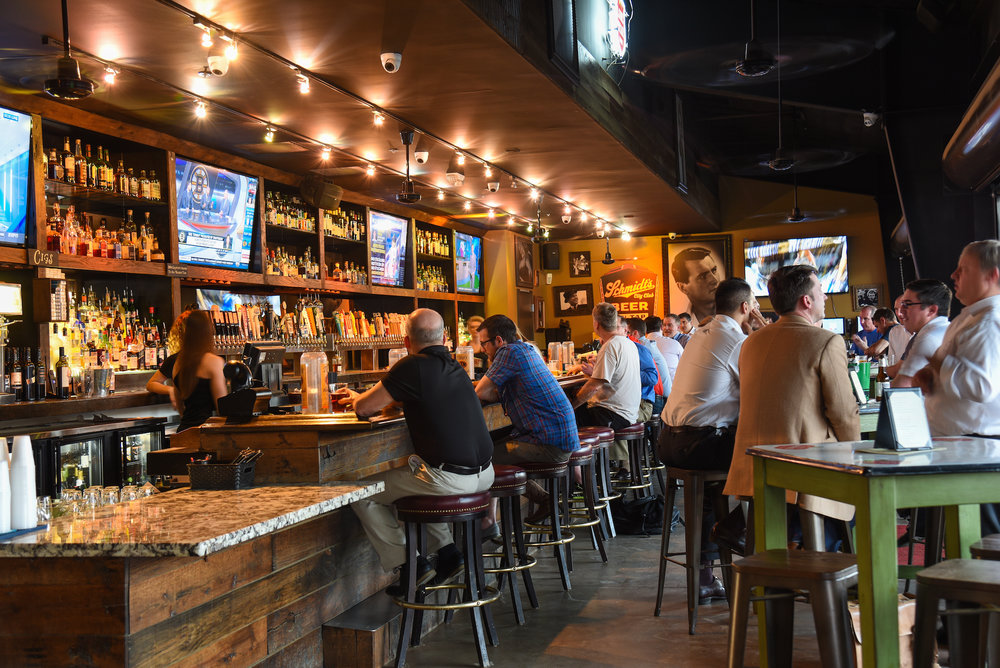 Patrons at the bar inside Kirby Ice House at Greenside in the evening